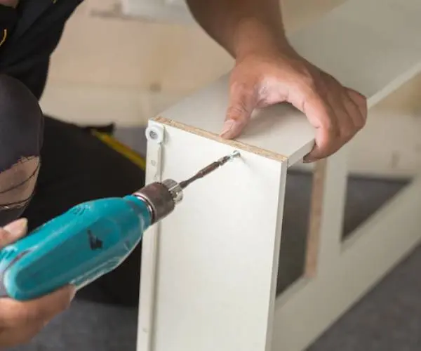 Klusjesman voert nauwkeurig montagewerk uit met een boormachine