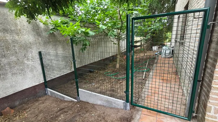 Groene metalen omheining met tuinpoort